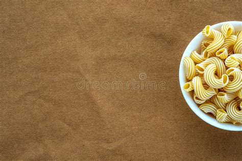 Rigati Pasta In White Bowl On Beige Brown Cloth Burlap Pattern With