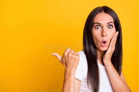 Photo Portrait Of Shocked Amazed Girl Pointing Thumb Empty Space Touching Cheek Isolated On