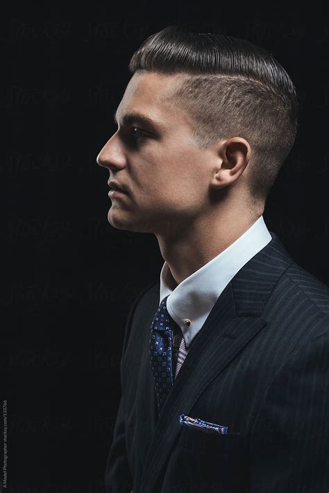 A Profile Of A Handsome Young Man In A Business Suit On Black By