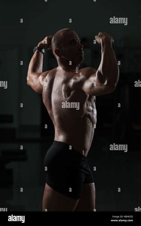 Bald Man Standing Strong In The Gym And Flexing Muscles Muscular
