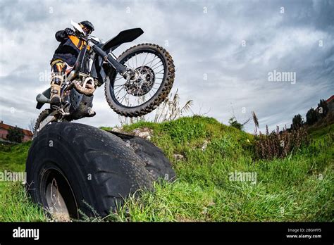 Enduro Bike Rider In Action Obstacle Overcome On Mud And Grass Terrain