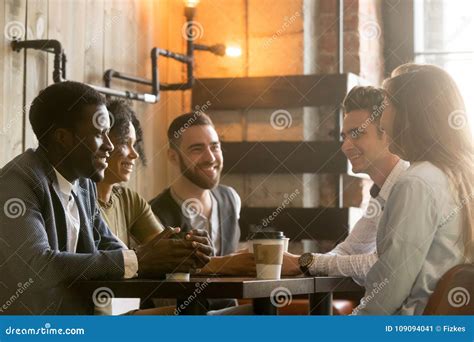 Multiracial Young Friends Talking And Drinking Coffee Sharing Co Stock