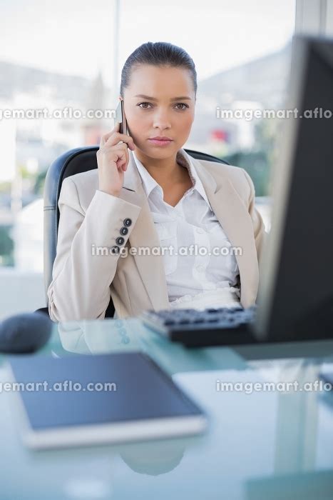 Serious Sophisticated Businesswoman On The Phone In Bright Officeの写真素材