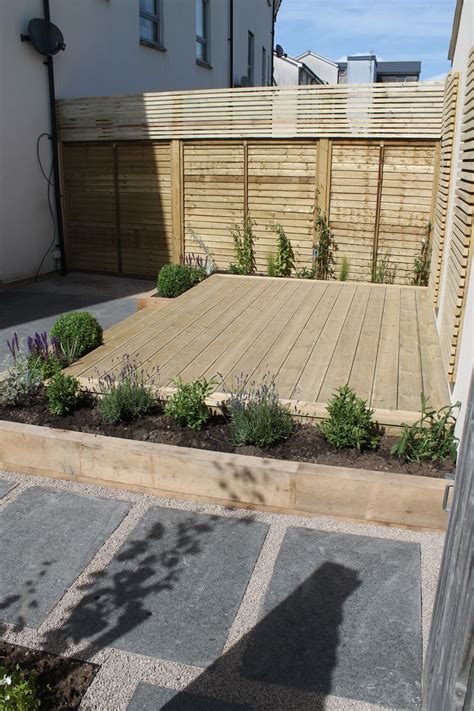 A Paved Terrace With Raised Planters Using Sleepers Decked Steps Then