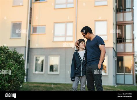 Father With His Arm Around His Son In A City Stock Photo Alamy