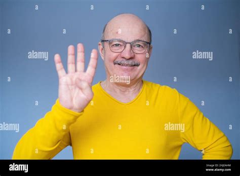 Senior Man Raising Hand Showing Number Four With Fingers Counting