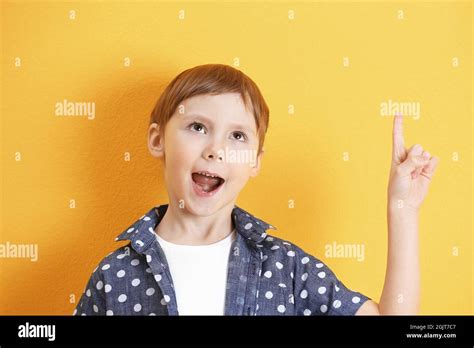 Cute Little Boy With Index Finger Up On Color Background Stock Photo
