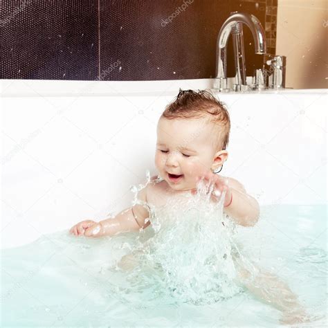 Cute Baby Having Fun Splashing Water And Laughing While Taking A Bath