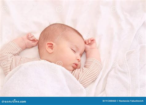 Peaceful Baby Lying On A Bed While Sleeping In A Bright Room Stock