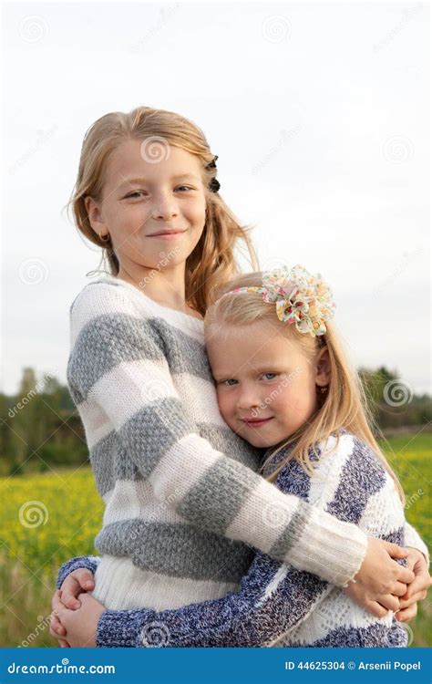 Verticale De Deux Petites Filles Mignonnes De Embrassement Photo Stock