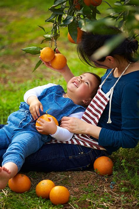 Little Asian Girl With Her Mother In The Orange Farm Del Colaborador De Stocksy Bo Bo Stocksy
