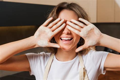 jeune jolie femme au foyer dans la cuisine avec de la farine sur des mains photo stock image