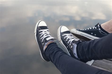 parenvoeten in tennisschoenen die door het water ontspannen stock afbeelding image of