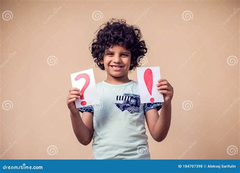 A Portrait Of Kid Boy Holding Cards With Question Mark And Exclamation