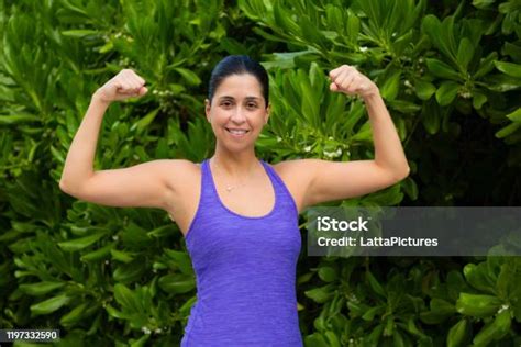 Portrait Of Fit Hispanic Female Flexing Her Bicep Muscles Stock Photo