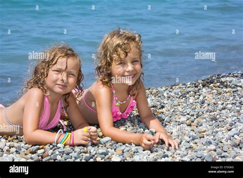 Zwei H Bsche M Dchen Auf Steinigen Strand In Der N He Von Meer Liegend Stockfotografie Alamy