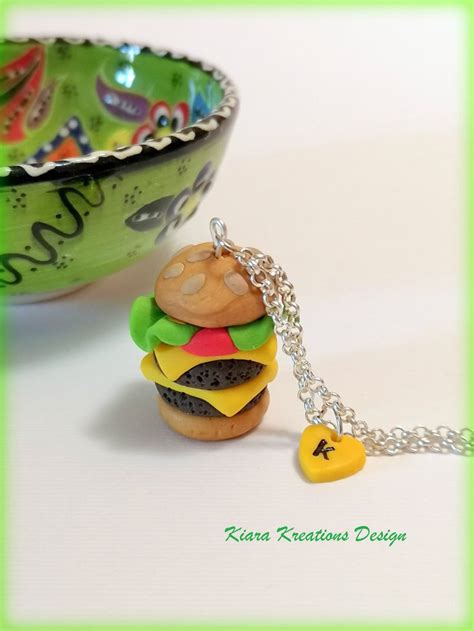A Small Toy Hamburger Sitting On Top Of A Table Next To A Bowl And Chain