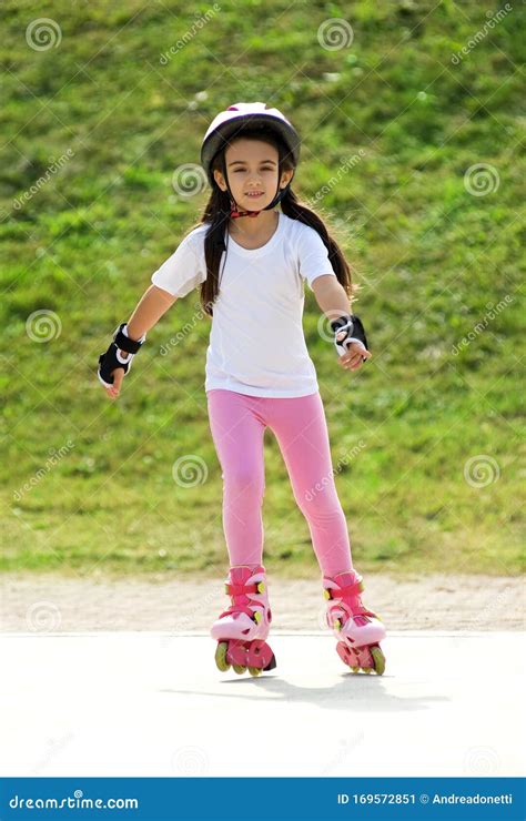 Girl In Roller Skates Drinking Water And Listening To Music On H Stock