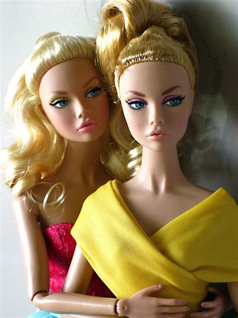 Two Barbie Dolls Sitting Next To Each Other Wearing Yellow Dresses And