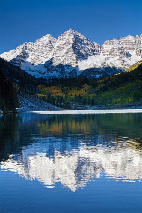 Snow Capped Peaks And Fall Foliage At Maroon Bells Aspen Colorado