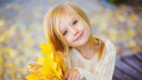 Smiley Cute Girl Is Holding Yellow Leaves With Hands Wearing Half White