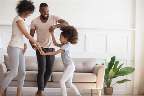 Happy biracial family with kid dancing at home - Westbow Construction