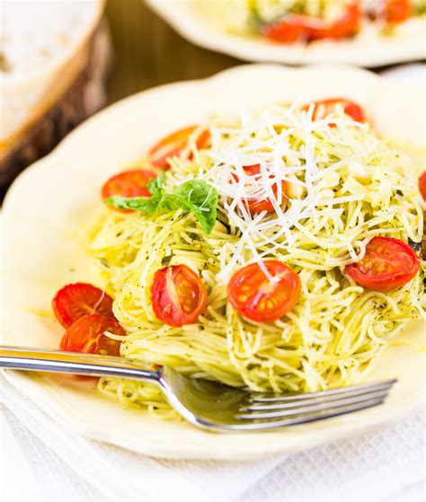This angel hair pasta recipe is tender noodles coated in garlic, fresh herbs, olive oil, butter and parmesan cheese and topped with tomatoes. Angel Hair Pasta with Lemon & Garlic