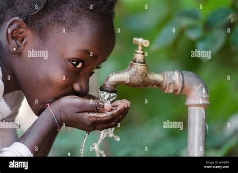 Beautiful African Child Drinking From A Tap Water Scarcity Symbol