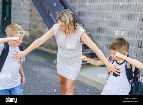 Teacher Stopping Two Boys Fighting In Playground Stock Photo Alamy