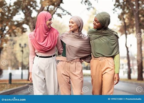 Three Muslim Women Wearing Hijab And Modern Clothes Walking Outside
