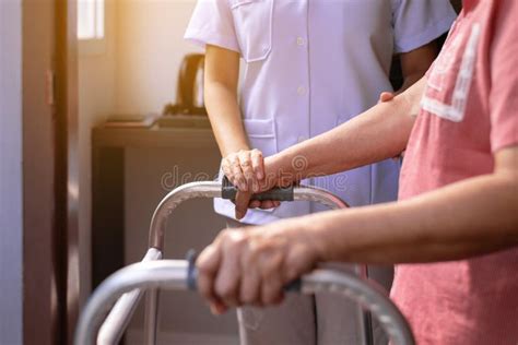 Nurse Helping Senior Woman Hand Holding Walker Trying To Walkcare