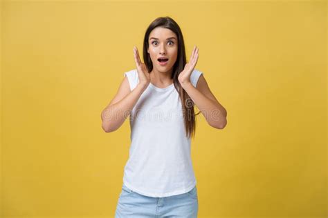 surprised teenage girl show shocking expression with something isolated on bright yellow
