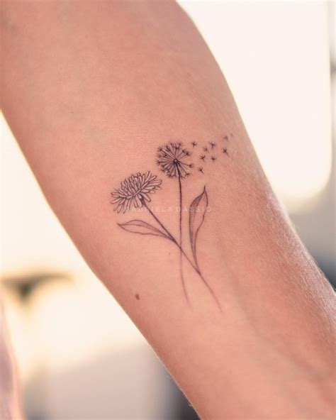 A Womans Arm With A Dandelion Tattoo On It
