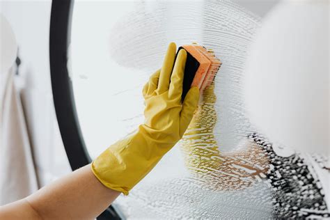 Faceless Person Cleaning Mirror With Sponge · Free Stock Photo