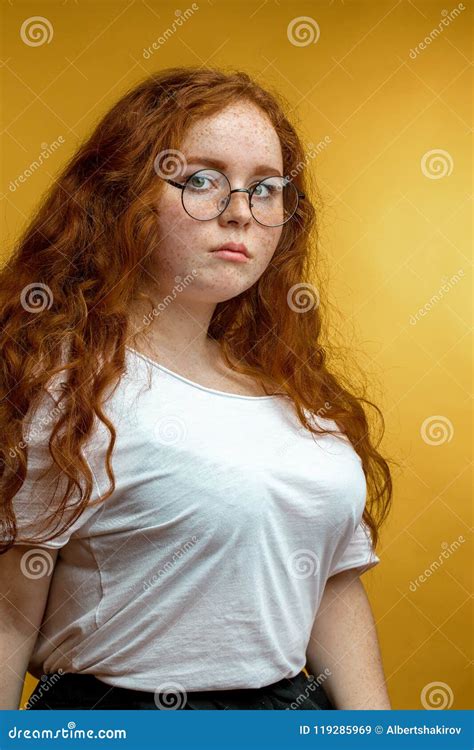 Young Woman With Unfasten Ginger Hair On Yellow With Calm Expression