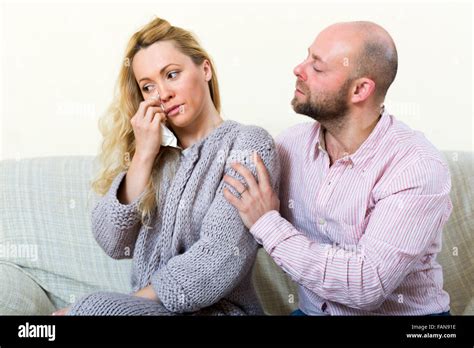 Sad Woman Has Problem Man Consoling Her On Sofa At Home Stock Photo