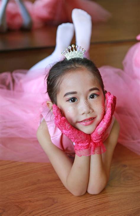 little ballerina girl in a pink tutu lying on the floor with looking at camera stock image