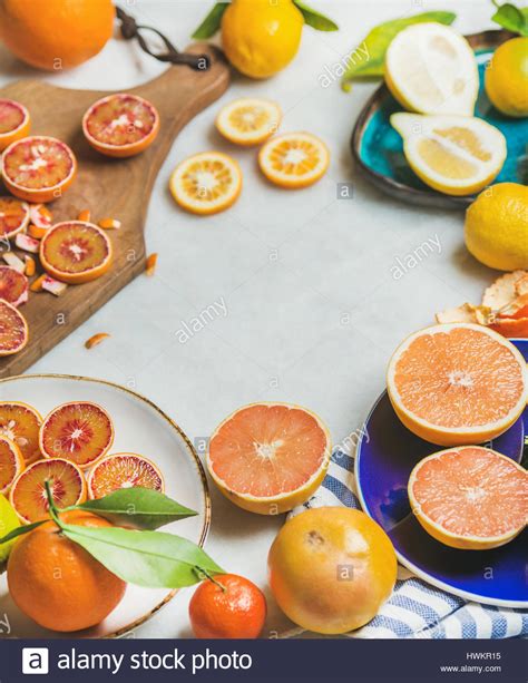 Natural Fresh Citrus Fruits In Colorful Ceramic Plates And Wooden