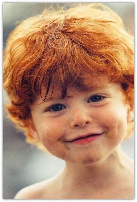 A Three Year Old Redhead Boy Smiles At The Camera On A Hot Summer Day