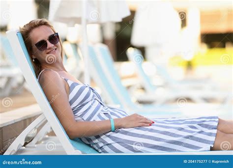 Woman In Sunglasses And Dress Lie On Lounger On Beach And Sunbathes Stock Image Image Of