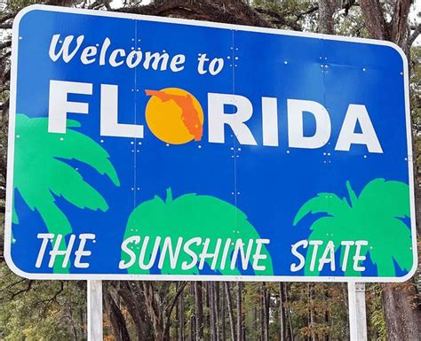 A Welcome To Florida Sign With Palm Trees In The Background
