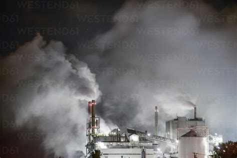 Smoke Emitting From Factory At Night Stock Photo