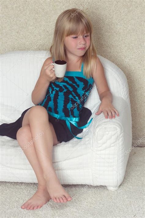 5 лет девушка сидит на диване с чашкой Стоковое фото victoshafoto