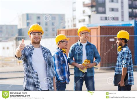 Group Of Smiling Builders In Hardhats Outdoors Stock Photo Image Of