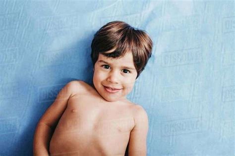 From Above Of Cheerful Shirtless Little Boy Looking At Camera While