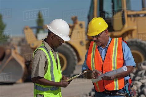 Two Construction Workers Working On Building Site Stock Photo Dissolve