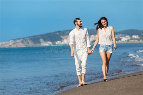 Couple Walking On Beach Young Happy Interracial Couple Walking On Beach Smiling Holding Around