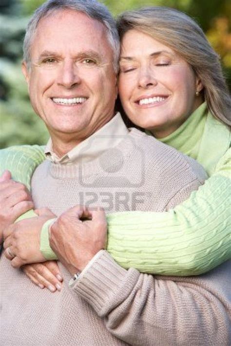 An Older Couple Hugging Each Other Outside