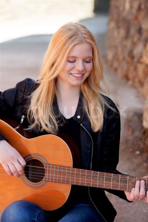cool blonde girl playing guitar outdoor stock image colourbox