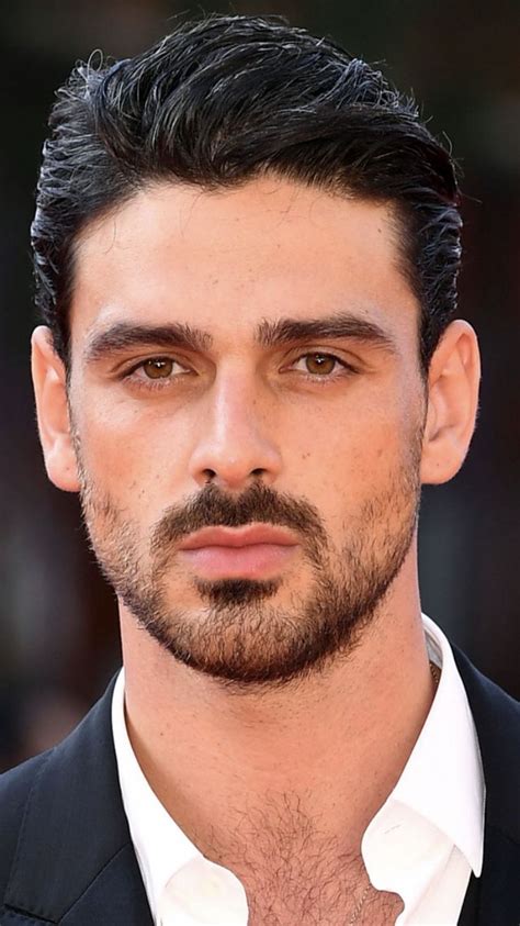 A Close Up Of A Person Wearing A Suit And Tie With A Goatee On His Head